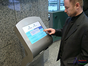 man at a touch screen kiosk
